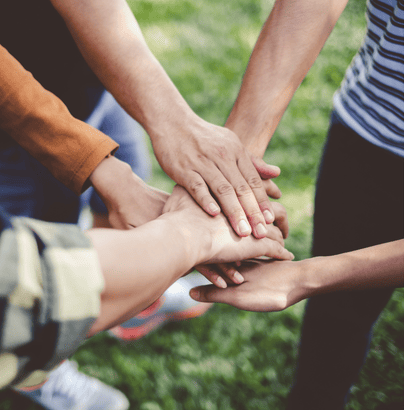 un grupo de gente junta sus mano como gesto de unidad