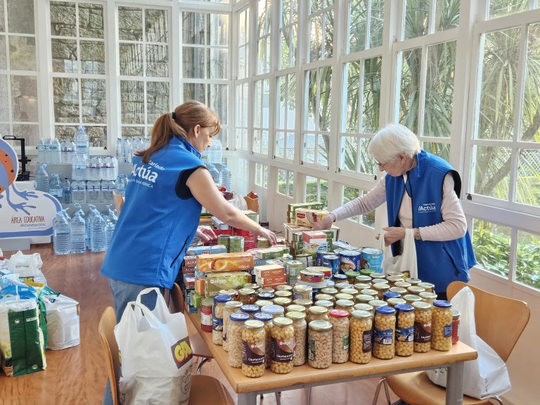 dos personas colaboran recogiendo alimentos para repartir en personas con bajos recursos